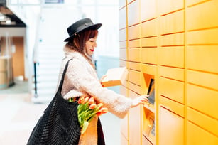 fashion-woman-with-box-using-modern-postal-automat-2023-02-10-15-23-55-utc (Medium)